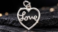 Front view of silver heart pendant with “Love” script