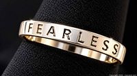 Close-up of ring showing FEARLESS lettering and silver-tone finish