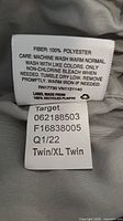 Care label showing 100% polyester composition, size Twin/XL Twin, Target brand