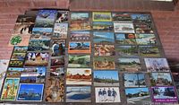 Fronts of all 45 postcards laid out showing various travel scenes