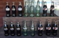 Group view of sealed commemorative and empty bottles on crate