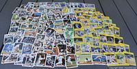 Overhead view showing full assortment of white-border and yellow-border baseball cards spread out