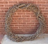 Front view of entire grapevine wreath against brick wall