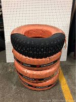 Stack of four Yokohama tires with orange protective wrapping and visible tread pattern