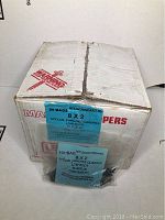 Box containing 25 bags of 2 inch Special Pancake Quadrex black screws with Robertson bits, each bag sealed and labeled with product info.