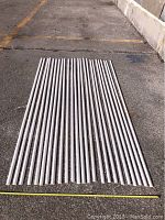 24 pieces of primed finger jointed pine shoe moulding laid out parallel on ground showing length and quantity.