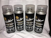 Four cans of Varathane Professional Clear Finish Satin spray finish, front view showing branding and product name.