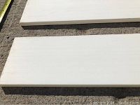 Close-up photo of the primed MDF flat baseboards showing smooth white primed surface and flat design.