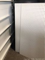 Two white pegboards stacked together showing their full height and width with the pegholes visible.