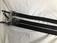 Three new black men's size 44 belts with polished silver buckles laid out showing length and details.
