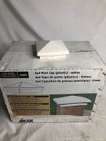 Box with a white 4x4 plastic post cap placed on top showing the product and branding details.