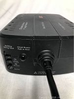 Side view showing circuit breaker push reset button, building wiring fault indicator, and data/modem line protection ports.