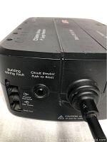 Close-up view of the side panel showing modem/phone/fax data ports, circuit breaker reset button, and power cable connection.