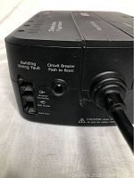 Close-up of side panel showing building wiring fault, circuit breaker reset button, and data port for modem/phone/fax line.