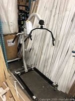 Front-left view of the Hoyer Deluxe power patient lift showing base legs, mast, and boom