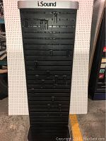 Front view of black two-sided display rack showing multiple metal hooks and the i.Sound branded silver panel on top.