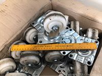 Twenty castors with 3-inch nylon wheels mounted on metal swivel plates, displayed in cardboard box alongside a measuring ruler to show size, close-up photo to detail structure and materials.