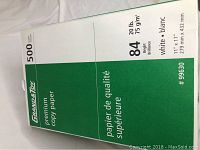 Close-up showing the label on the side of a ream of Grand & Toy premium copy paper indicating 500 sheets, 11 x 17 size, 20 lb weight, and 84 brightness.
