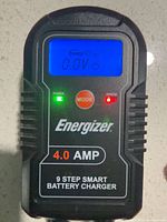 Front view of charger showing LCD, controls and branding