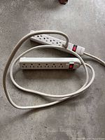 Front view of both 6-outlet power strips coiled together showing outlets and switches