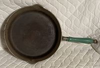 Top view of cast iron skillet with green wooden handle