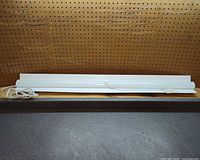 Full view of white linear shop light fixture front