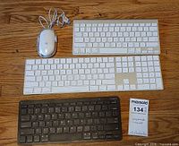 All four items laid out: Apple mouse, two Apple keyboards, Targus keyboard