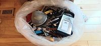 Bag filled with assorted stainless steel and plastic-handled kitchen utensils