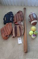 Overview of gloves, bat, football, softball, tennis balls