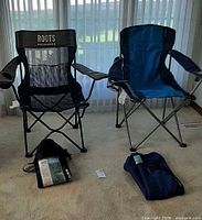 Both folding chairs standing with carry bags on floor