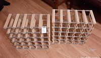 two identical wood-steel wine racks side by side on floor