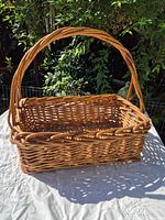 Overall view of rectangular wicker basket with arched handle