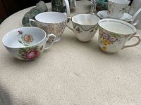 Four assorted floral bone china teacups on tabletop