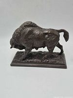 Side view of buffalo sculpture on base