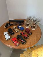 Group shot of all eight cars, truck and six shot glasses on round table