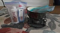 Fondue pot set with bottles and forks bagged