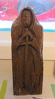Front view showing carved hooded knight holding sword