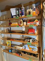 Wall shelves showing sealants, tubes, hand tools, hardware, cords and accessories