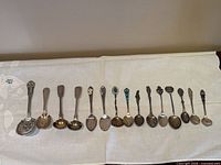 All 17 spoons laid out on cloth showing variety and quantity
