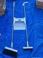 Full view assembled broom, hand brush and dustpan on blue tarp