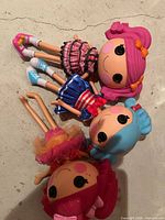 Three Lalaloopsy dolls lying side by side showing full outfits and hair colors