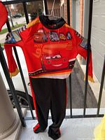Front view of toddler Cars jumpsuit hanging
