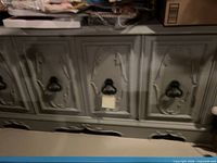 Front view of gray hutch showing four ornate doors and ring pulls