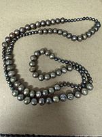 Full view of entire continuous strand of baroque gray-black pearls