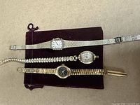 Overall view of three wristwatches displayed on velvet case