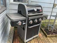 Front and side view of the Coleman grill showing shelves, control panel and overall condition