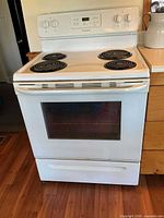 Front view of white Frigidaire electric range showing oven door and coil burners
