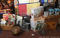 Wide shot showing basket with assorted kitchen items, wooden rooster canister set, glass cannisters, chafing dish and boxes