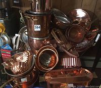 Full lot overview showing stacked copper saucepans, molds and pans