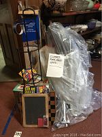 Disassembled clothes rack, bingo set, checkerboards, crayons, slate and chalk set grouped together for auction.